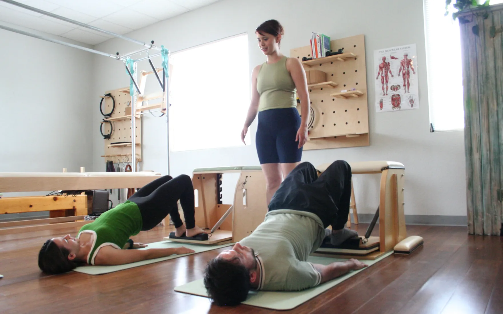 Luz guiding two clients through a mat and apparatus class at La Luz Body Align